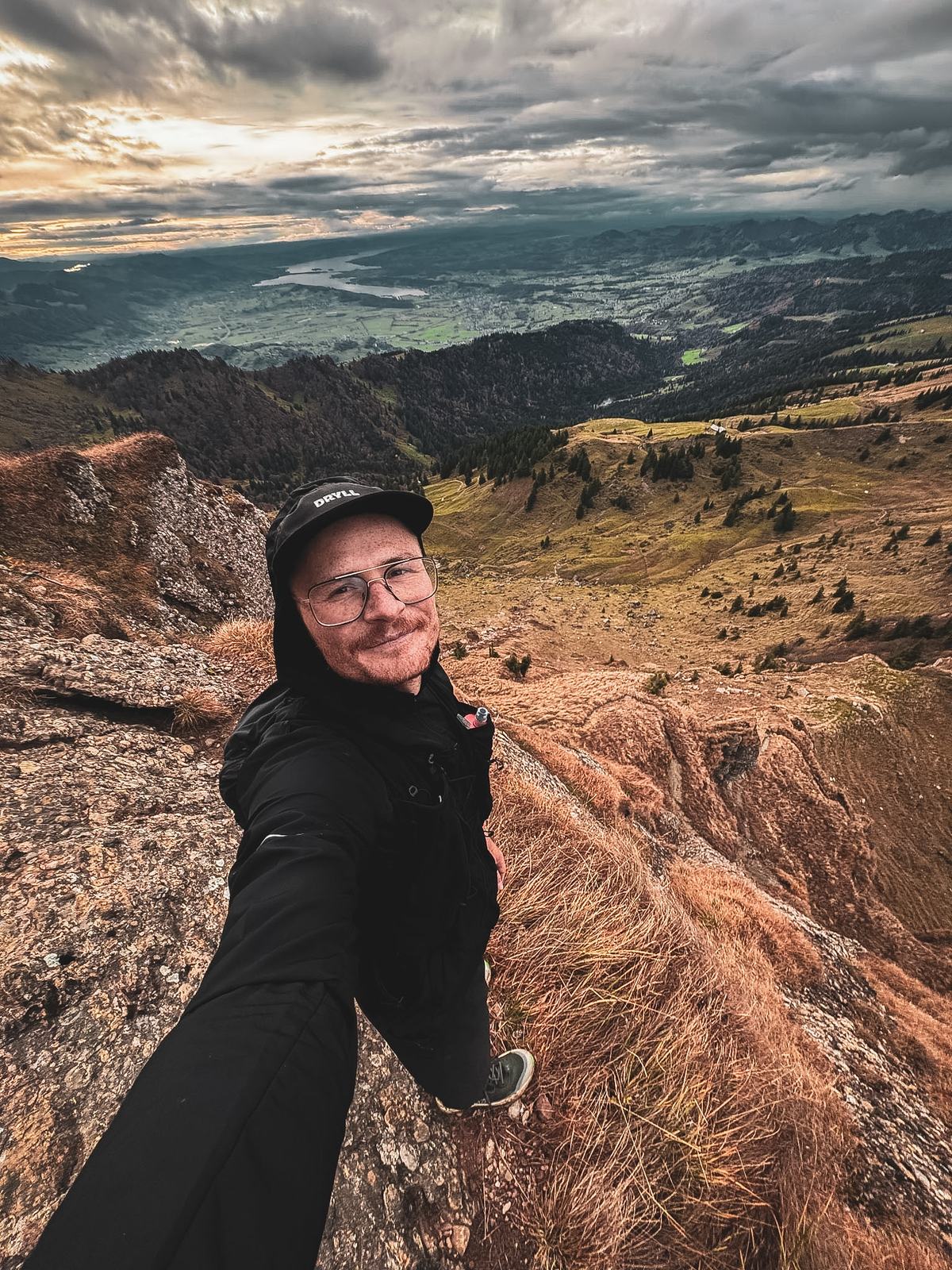 Pierre Biege auf einem Grat im Herbst, unten das Tal und Wolken